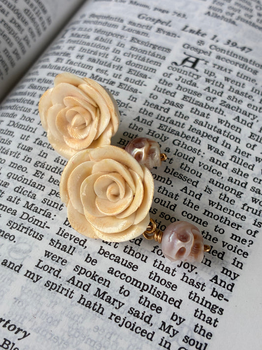 Mary Magdalen rose studs laying on a page from a Sunday missal